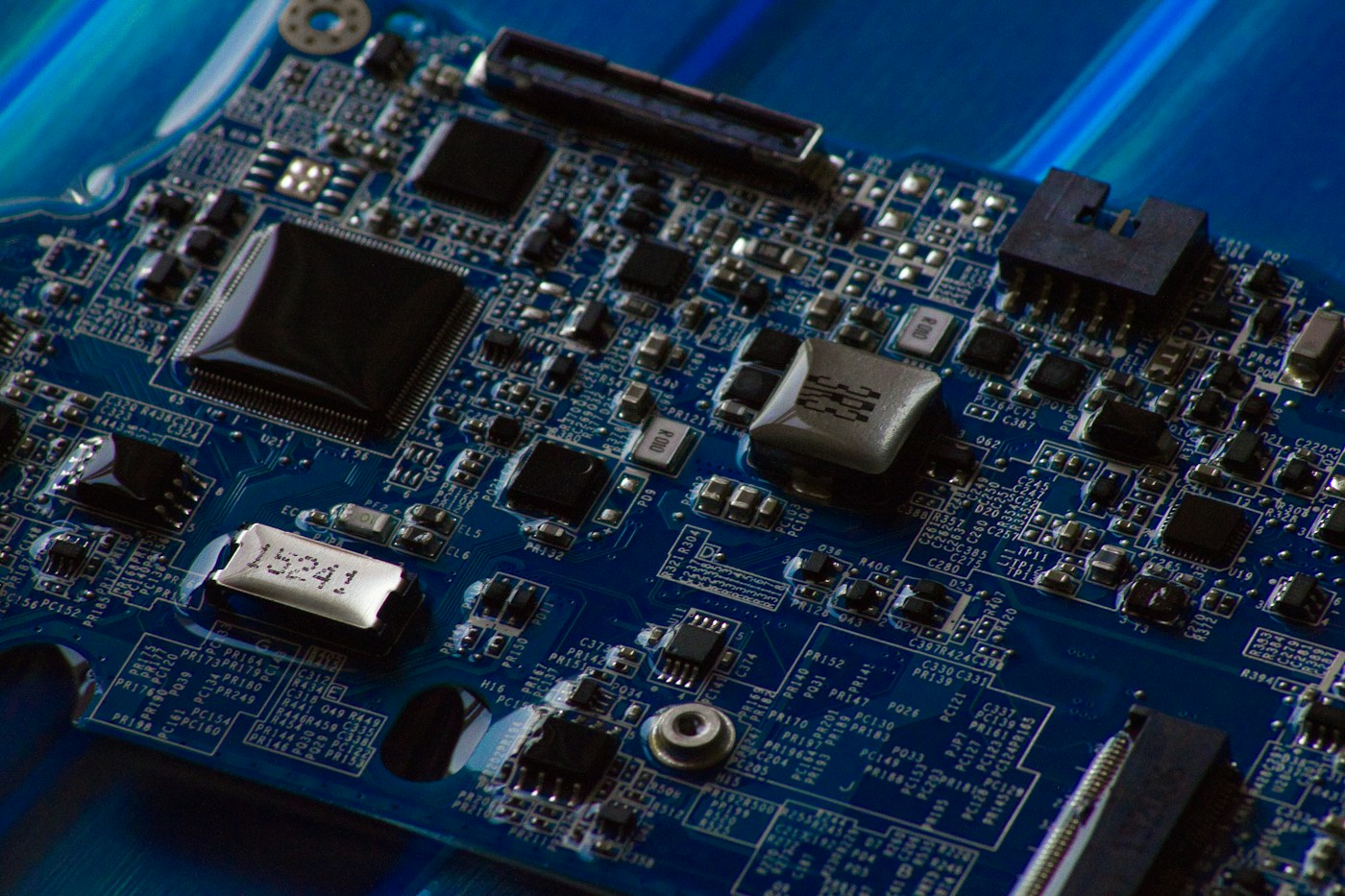 close-up of a blue circuit board with chips and electronic components