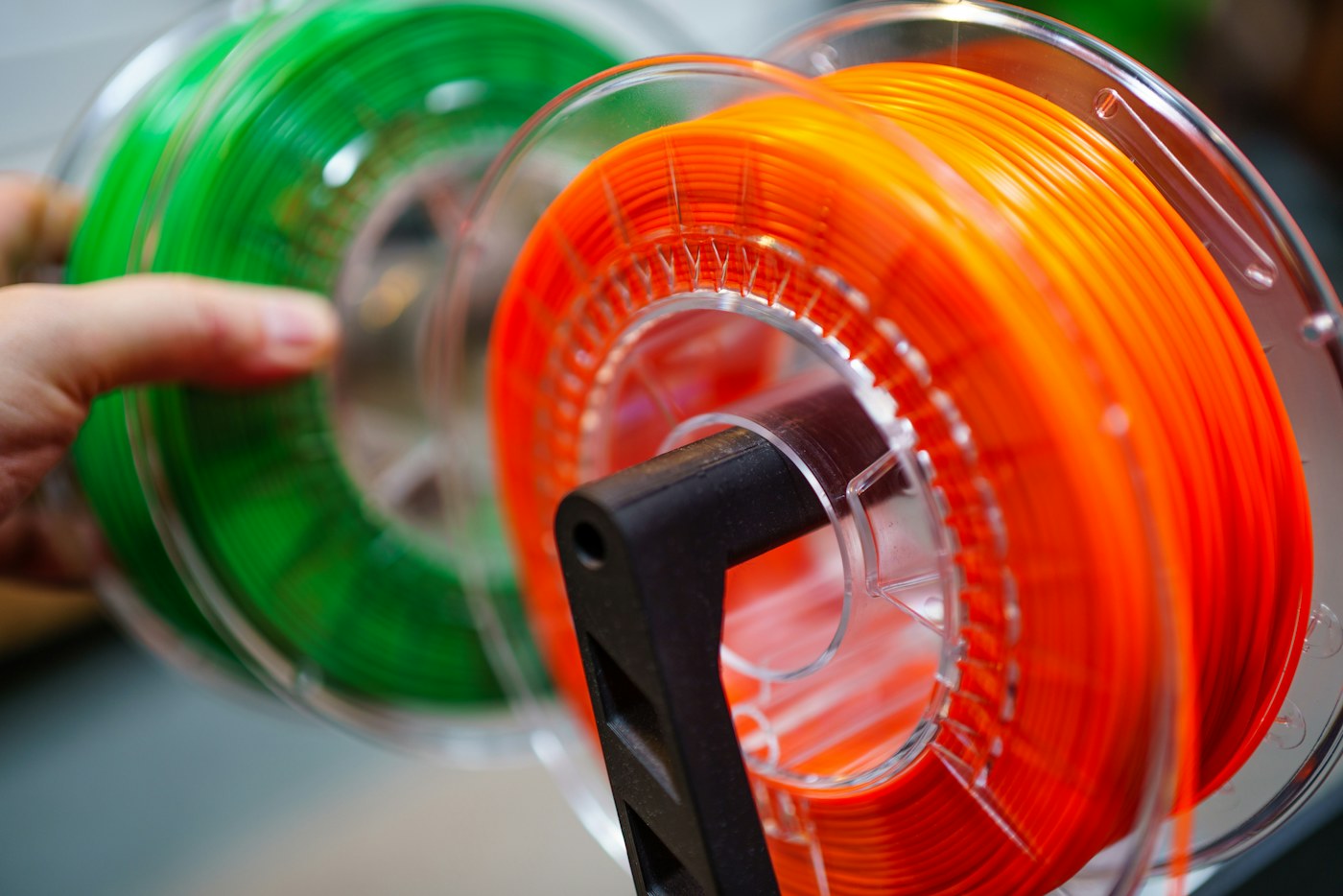 orange and green polymer filament on spools